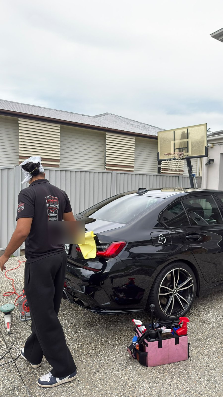 Platinum Car Care technician detailing a BMW on site, full mobile kit set up beside the car